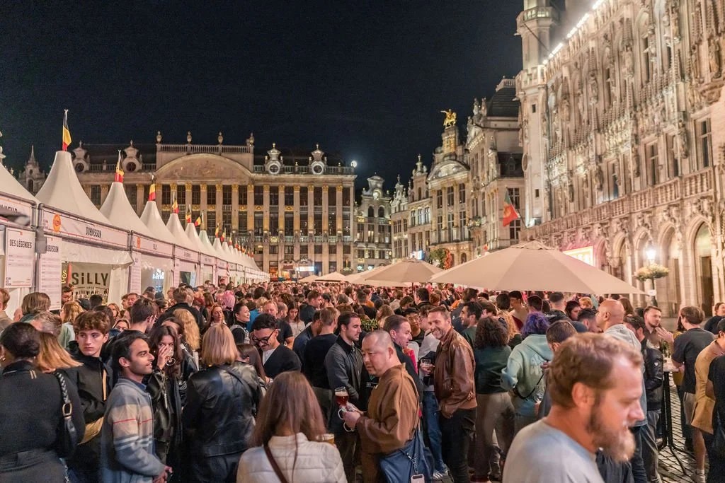 Tendas iluminadas e multidão na Grand-Place de Bruxelas durante o Belgian Beer Weekend