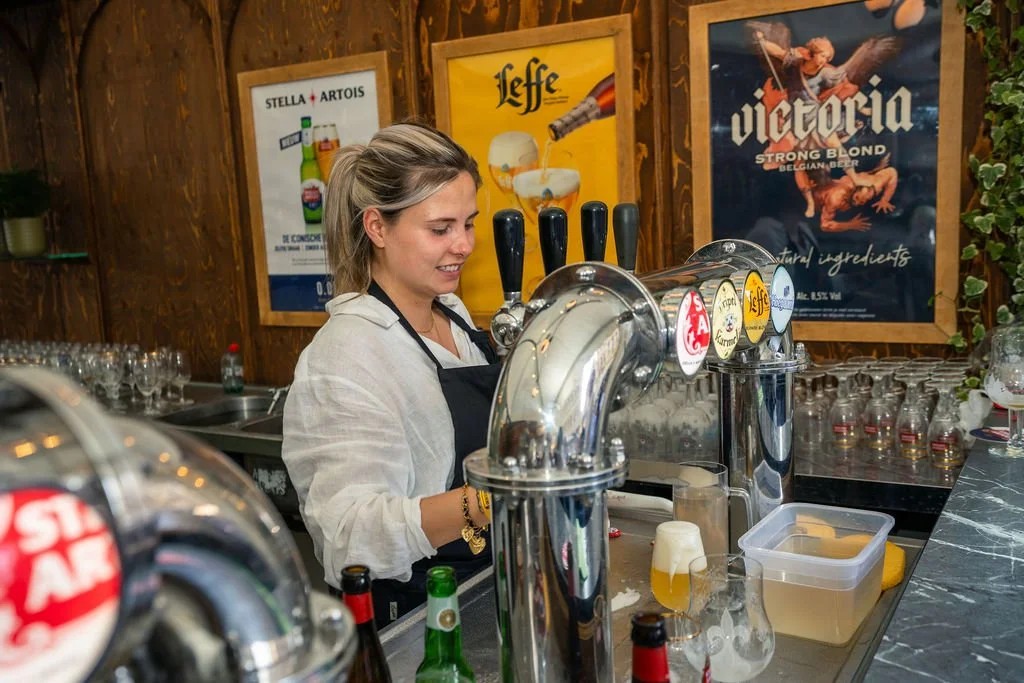 Empregada a tirar cerveja num stand do Belgian Beer Weekend