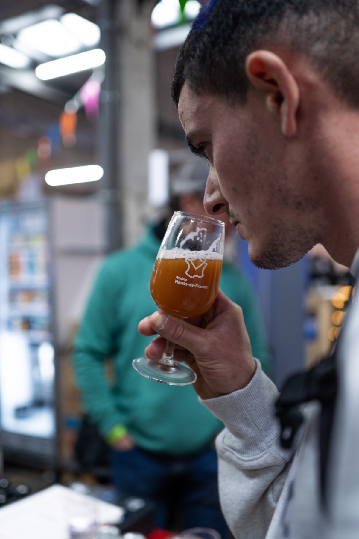 Visitante prova uma cerveja num copo Hauts-de-France no Bière à Lille