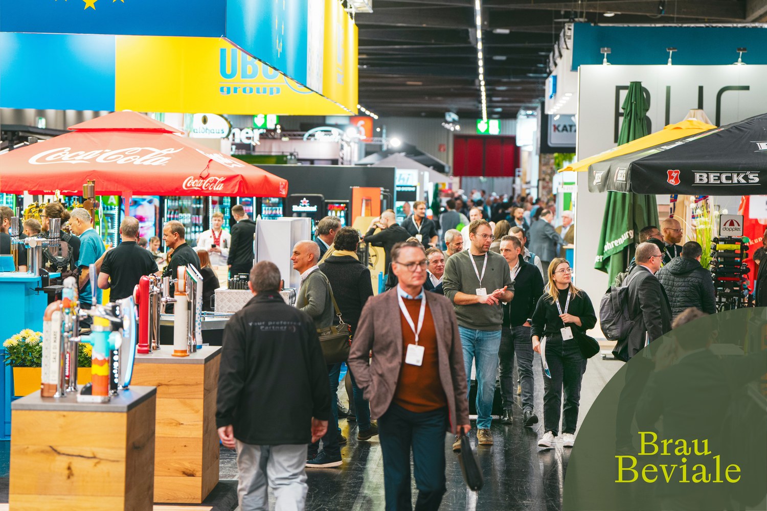 Corredor de um pavilhão da BrauBeviale com stands e visitantes