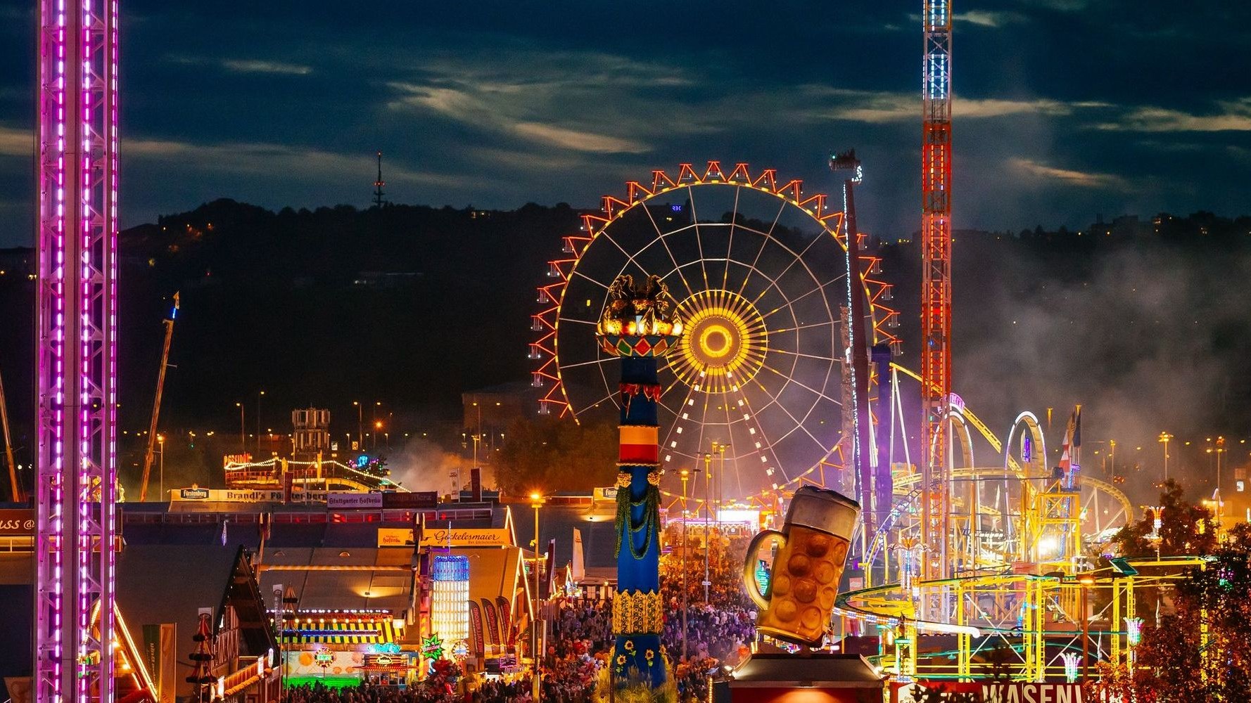 Cannstatter Volksfest 2026 — o Wasen à noite O recinto do Cannstatter Wasen ao anoitecer, com a roda gigante iluminada